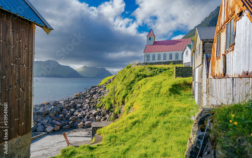 Traditional Faroe village of Kunoy with picturesque church and mountain photo