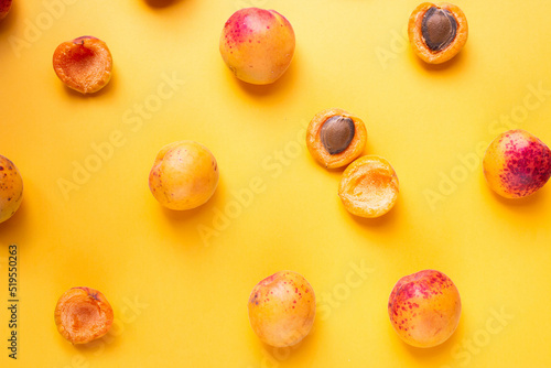 ripe apricots on orange table with leaves