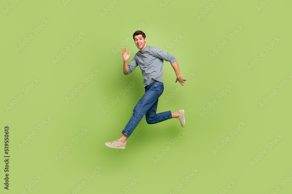 Full body profile side photo of cheerful man go on walk promenade say hi meet friend isolated on green color background