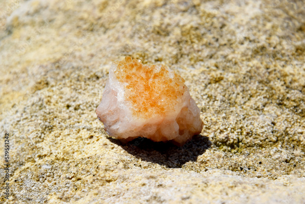 A beautiful druse citrine lies on a stone. Intergrowth of yellow crystals of semi-precious quartz in bright sunlight. A beautiful druse citrine lies on a stone. Intergrowth of yellow crystals of semi-precious quartz in bright sunlight.
