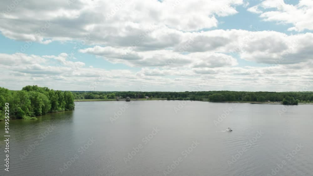 A static shot of a beautiful lakeside view in day time, with lush green trees, blue sky and sunlight A static shot of a beautiful lakeside view in day time, with lush green trees, blue sky and sunlight