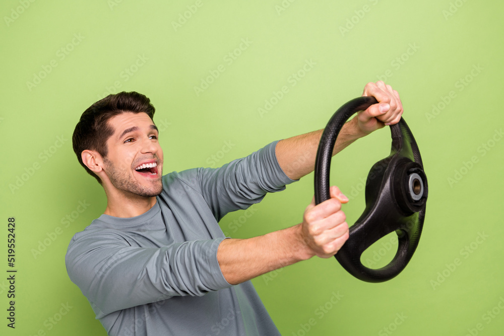 Profile photo of funny millennial brunet guy drive car look empty space wear grey pullover isolated on green color background Profile photo of funny millennial brunet guy drive car look empty space wear grey pullover isolated on green color background