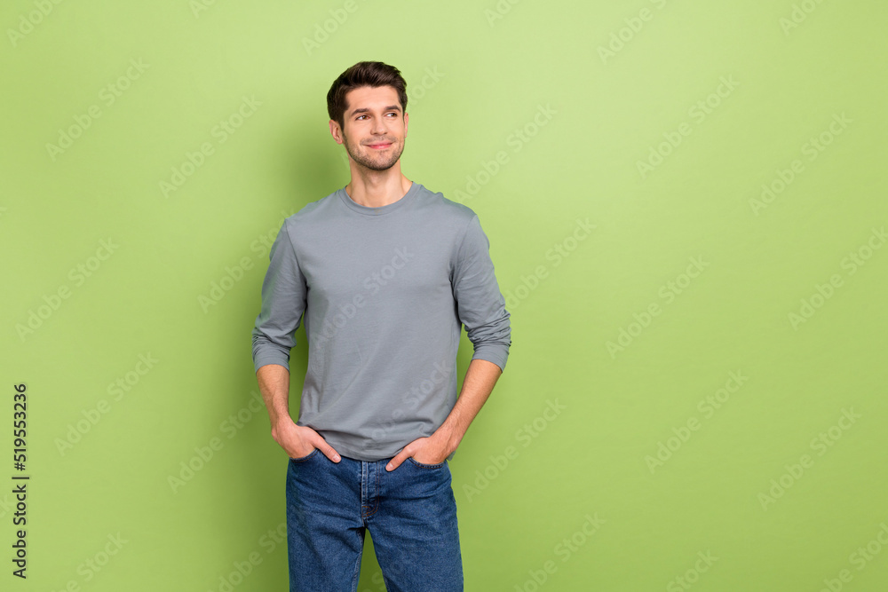 Photo of funky millennial brunet guy look promo wear grey pullover jeans isolated on green color background Photo of funky millennial brunet guy look promo wear grey pullover jeans isolated on green color background