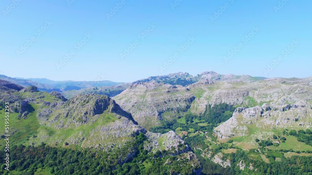 Aerial shot of breathtaking mountain in cantabria, Spain. Green forest and rocks. sunny day. Drone panning shot. Blue sky. High angle drone dolley shot. Aerial shot of breathtaking mountain in cantabria, Spain. Green forest and rocks. sunny day. Drone panning shot. Blue sky. High angle drone dolley shot.