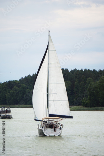 Fototapeta Naklejka Na Ścianę i Meble -  Sailboat swimming on a lake - back view