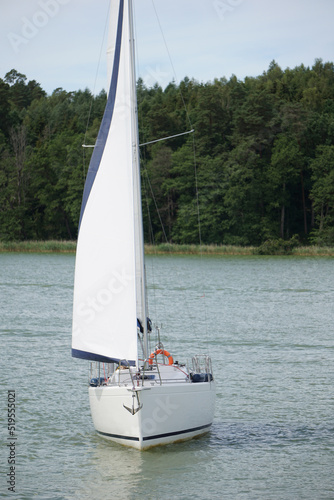 Sailboat swimming on a lake - front view