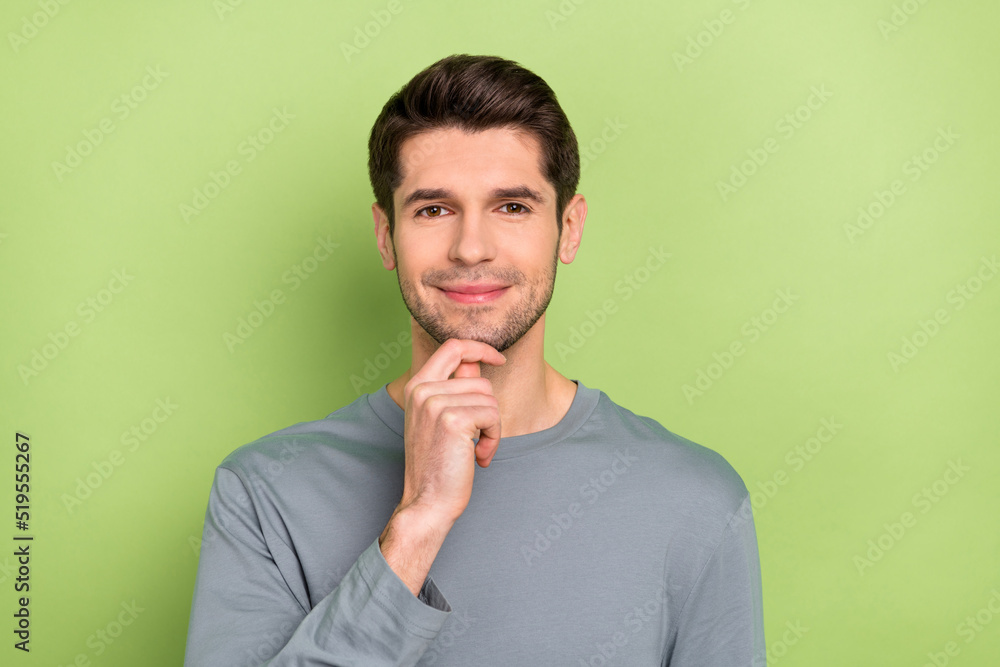 Photo of good young brunet guy hand face wear grey cloth isolated on green color background Photo of good young brunet guy hand face wear grey cloth isolated on green color background