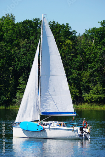 Fototapeta Naklejka Na Ścianę i Meble -  Sailboat swimming on a lake - side view