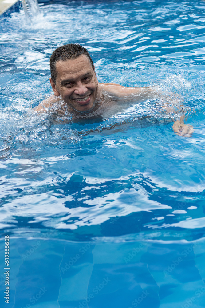 A mature man relaxes in his pool