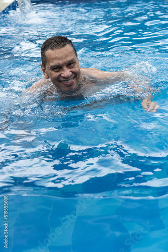 A mature man relaxes in his pool © Hector Pertuz