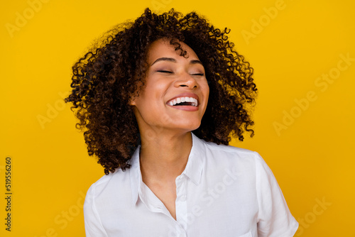 Photo of adorable gorgeous nice girl with wavy hairdo dressed white blouse toothy laughing eyes closed isolated on yellow color background