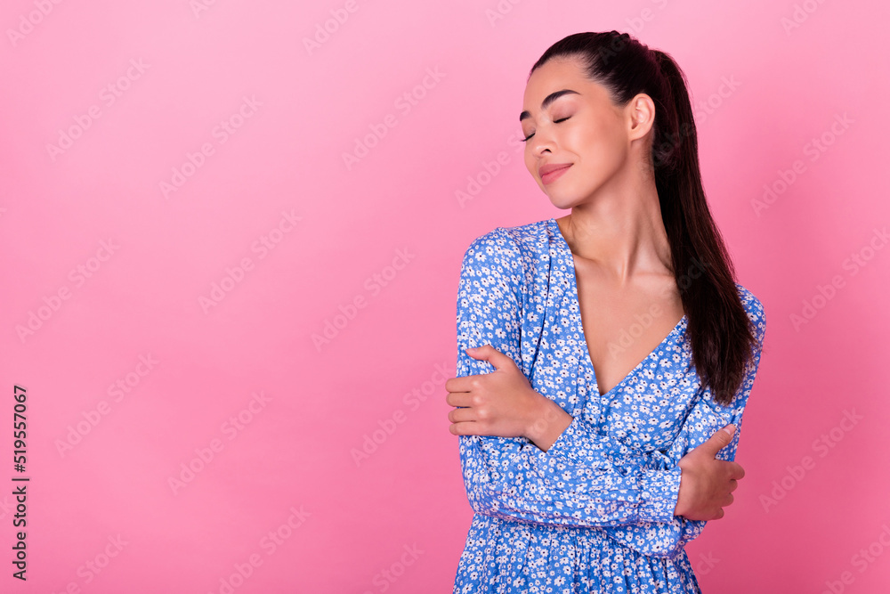 Photo of joyful brunette tail hairstyle lady hug herself wear floral dress isolated on pastel pink color background Photo of joyful brunette tail hairstyle lady hug herself wear floral dress isolated on pastel pink color background