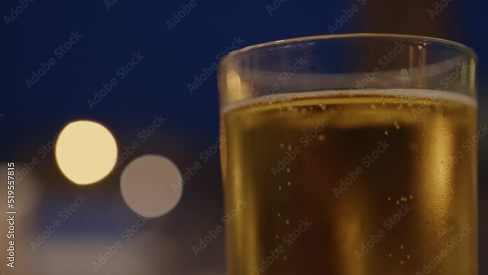 Glass of cold beer on background of defocused single lights, close up Glass of cold beer on background of defocused single lights, close up