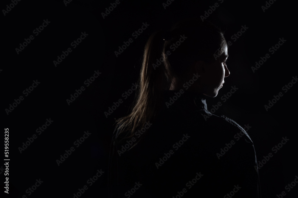 Female person silhouette in the shadow, back lit light