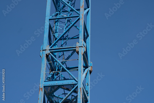 Tower Crane: Detail of the crane tower with the internal staircase, structure with tolerable rust spots, the tower is made up of steel elements with a reticular structure.