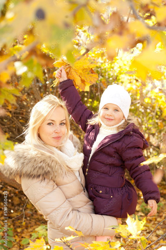 Happy family portrait, blonde mother and her daughter in autumn park Happy family portrait, blonde mother and her daughter in autumn park