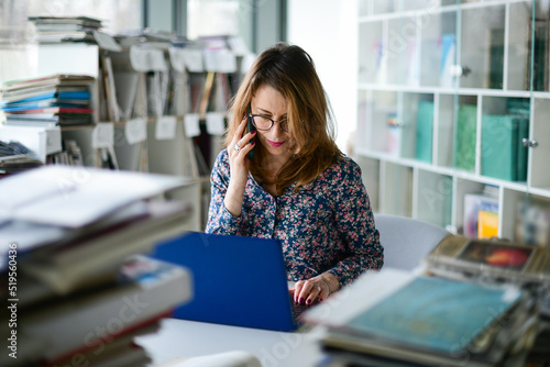 Woman in library searching information via laptop computer