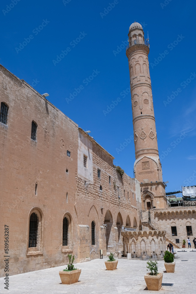 Ulu Mosque courtyard, fountain and minaret with blue sky in old Mardin.
