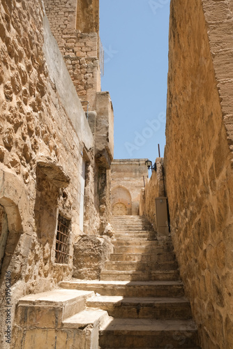 Old Mardin narrow street with stairs and old historical buildings.