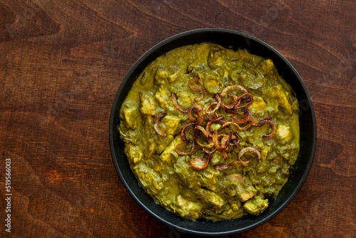 Turkey meat in coriander chutney with fried onion. Indian cuisine dish.