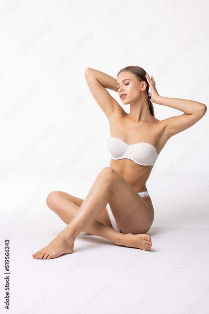 Young beautiful woman in white cotton underwear sitting on white background