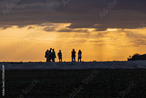 Tourists walk along a sandbank along the Rufiji River in southern Tanzania, East Africa © hyserb