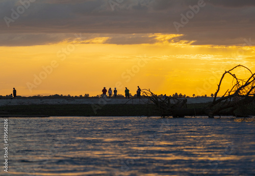 Tourists walk along a sandbank along the Rufiji River in southern Tanzania, East Africa photo