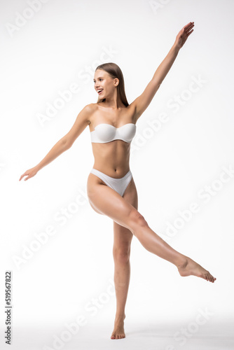 Full height of young woman with perfect body standing isolated on white background