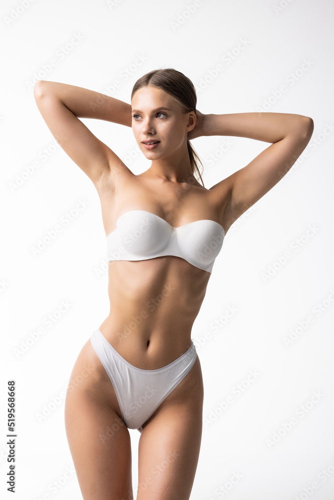 Fit woman in lingerie isolated on white background. Slim attractive female with flat belly in white underwear posing. Copy space for text. Fit woman in lingerie isolated on white background. Slim attractive female with flat belly in white underwear posing. Copy space for text.