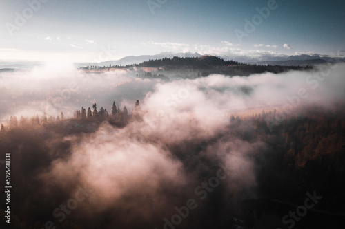 Incredible aerial view of mountains and nature covered in morning clouds