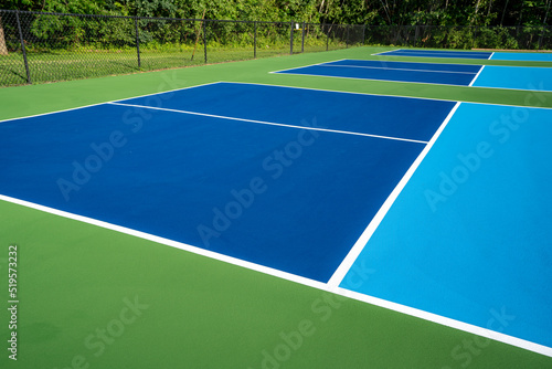 Example image of a newly surfaced, empty pickleball court with multi-color surface and white lines. 