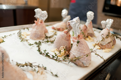 Cook preparing chicken confit leg.