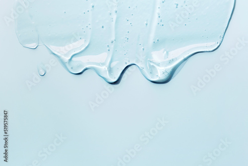 Liquid gel abstract cosmetic blue background. Smear of transparent moisturizing product photo