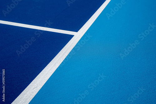 Example image of a newly surfaced, empty pickleball court with multi-color surface and white lines.
