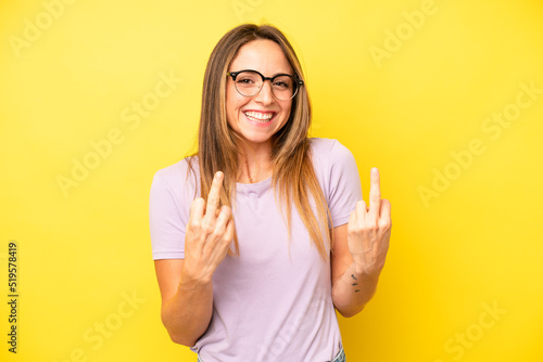 pretty young adult woman feeling provocative, aggressive and obscene, flipping the middle finger, with a rebellious attitude