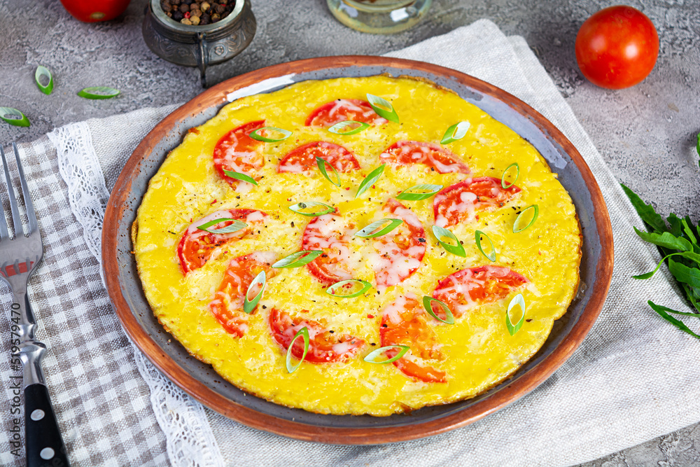Omelette with tomatoes, herbs and grated cheese. Easy breakfast