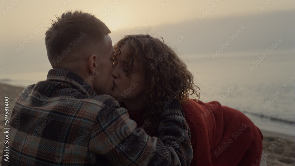 Romantic couple kissing on beach at sunrise. Girl and guy hugging each other Romantic couple kissing on beach at sunrise. Girl and guy hugging each other