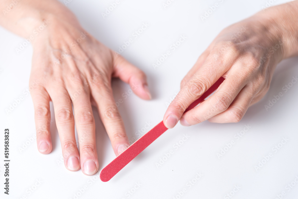 adult woman filing her nails, zenithal view, manicure, hand care, beauty and body health, at home adult woman filing her nails, zenithal view, manicure, hand care, beauty and body health, at home