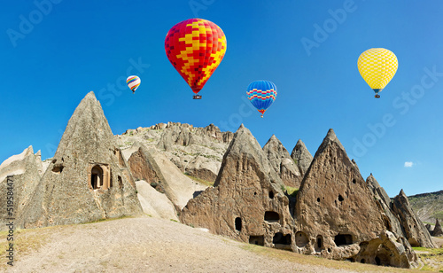 Colorful hot air balloons flying over volcanic cliffs at Cappado