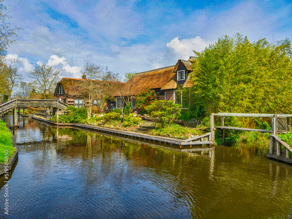 Dutch house and wodden bridge in the Dutch village of Giethoorn, Netherlands Dutch house and wodden bridge in the Dutch village of Giethoorn, Netherlands