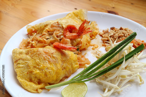 Delectable Thai Style Fried Noodle Called Pad Thai Wrapped in Fried Egg and Topped with Prawns