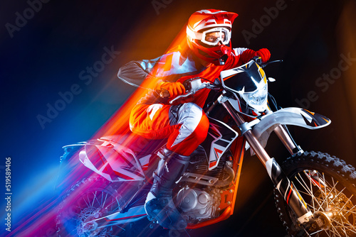 Portrait of young man, biker riding motorbike isolated over black background in neon with mixed lights. Speed development. © Lustre Art Group 