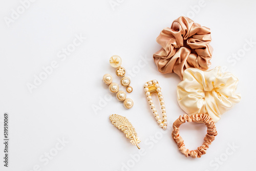 Collection of trendy silk elastic band scrunchies and pearl hair clips on white background. Diy accessories and hairstyles concept, luxury color photo