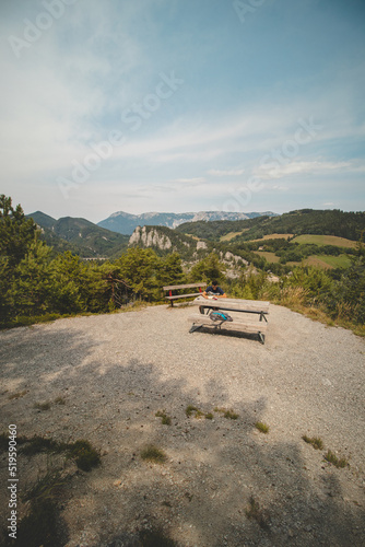 young active hiker rests on a rest area and reads a book overlooking the Kalte Rinne viaduct in Styria, northeastern Austria