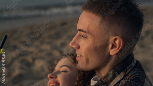 Happy couple posing for selfie photo on sea shore. Girl and guy taking selfie 