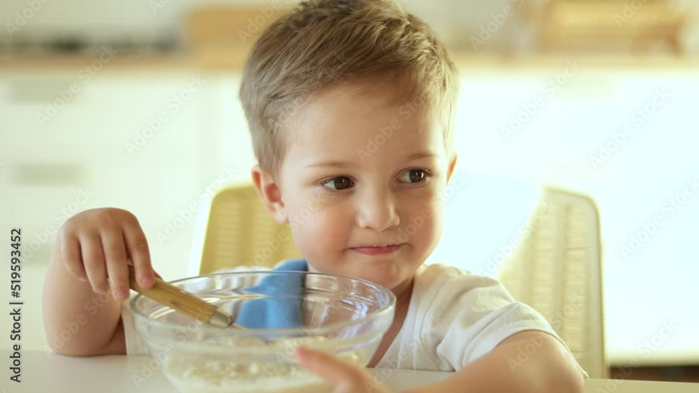 baby eats porridge. happy family a healthy eating concept. little boy son eating porridge with a spoon stained face. baby dirty dirty eating porridge himself funny video baby eats porridge. happy family a healthy eating concept. little boy son eating porridge with a spoon stained face. baby dirty dirty eating porridge himself funny video