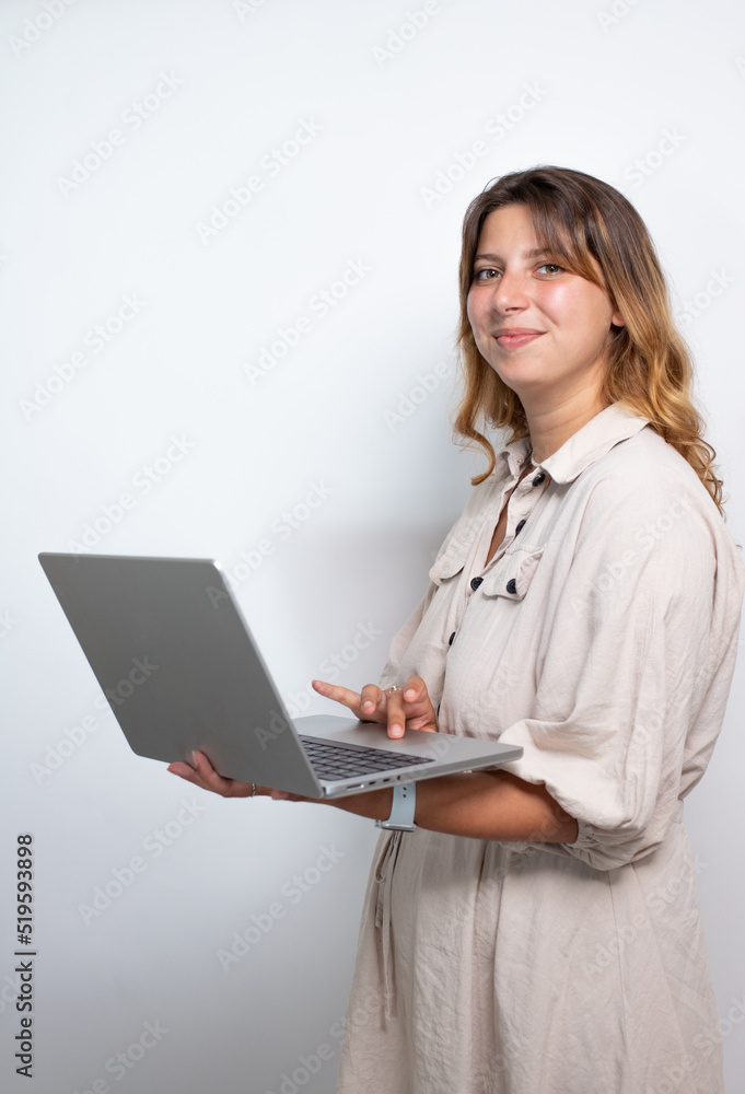 portrait d'une jolie jeune femme aux cheveux longs qui consulte son ordinateur portable. Isolé sur fond blanc. Place pour le texte. portrait d'une jolie jeune femme aux cheveux longs qui consulte son ordinateur portable. Isolé sur fond blanc. Place pour le texte.