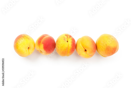 Row of ripe apricots on white background, yellow fruits.