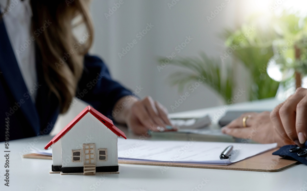 Fototapeta premium A professional female real estate agent receives a house loan payment or rent fee from her client. Property investment concept. cropped image