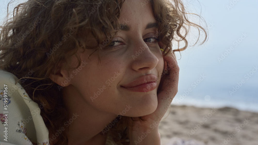 Cute girl raised legs in sand lying beach summer day close up. Curly woman relax Cute girl raised legs in sand lying beach summer day close up. Curly woman relax
